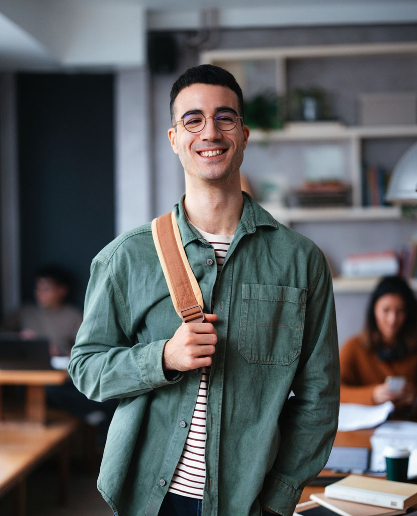 Young Student Smiling Confidently in a Cozy Library Cafe Setting