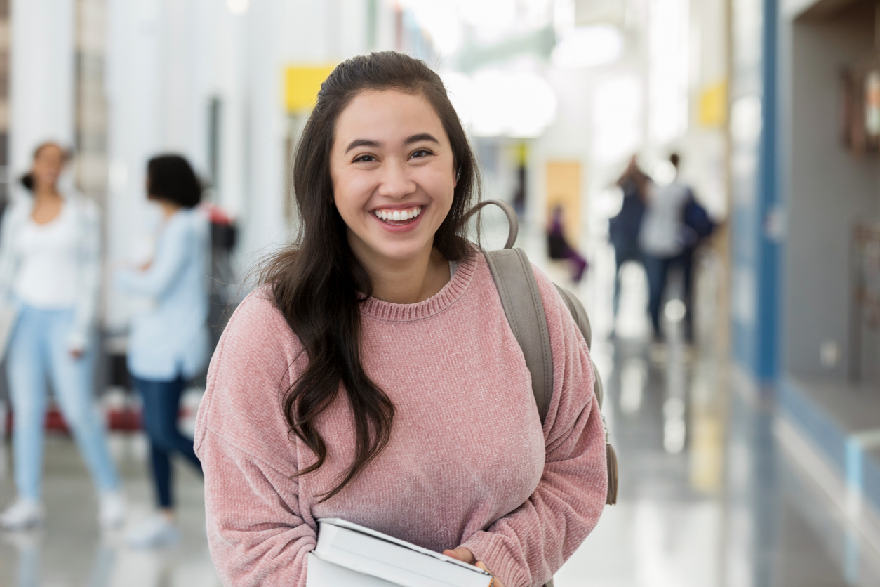 Young female in school hallway smiles