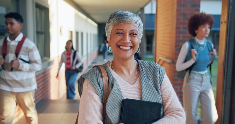Mature woman, portrait and teacher with confidence in school for higher education or learning. Female person, happy instructor or academic professor with smile for tutoring service or help on campus
