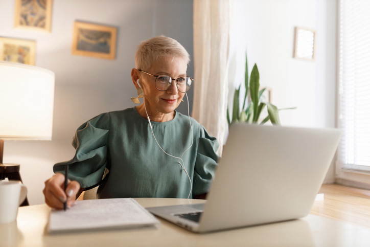 Woman working from home with a boston terrier dog. Freelancer businesswoman using laptop at sunny room. Student learning and working at home.